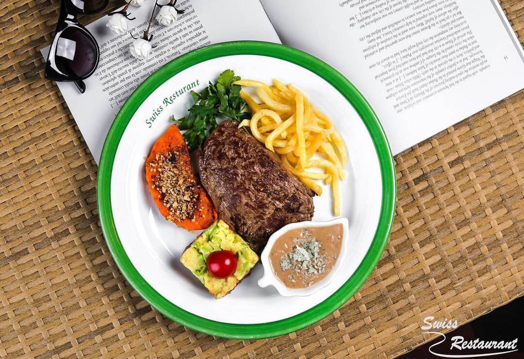 بشقاب استیک رستوران سوییس با دورچین سبزیجات و سس مخصوص